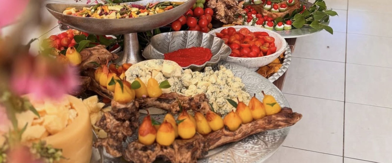 Mesa de antipasti com frutas, queijos e flores